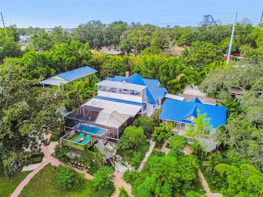 An aerial view shows a house with blue metal roofs, a pool, and lush landscaping — 3203 E YUKON STREET, TAMPA, FL