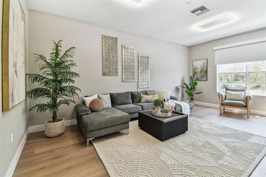 A living room features a grey sectional sofa, a black coffee table, and a large rug — 2547 LEXINGTON OAK DRIVE, BRANDON, FL