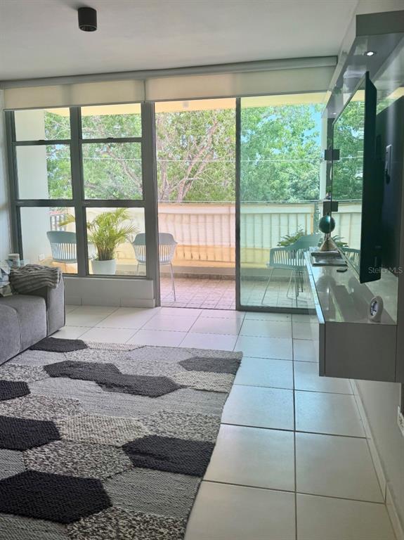 A living room with tile floors, a geometric rug, and a sliding door to a balcony — Apt 1805 CONDOMINIO LAS PRIMAVERAS UNIT 1805, CAROLINA, PR