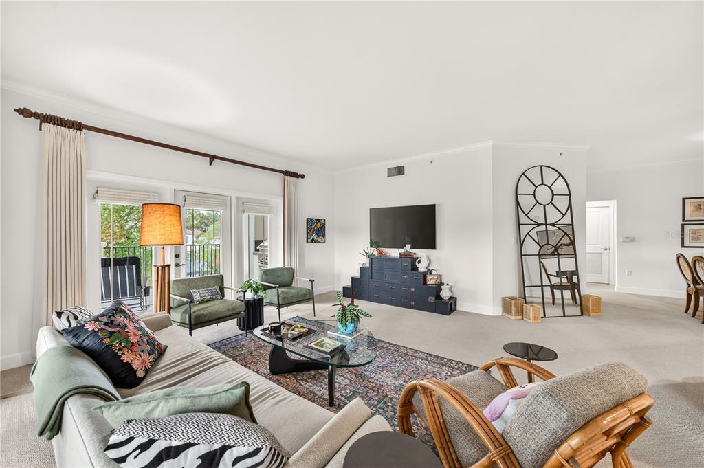 A living room features a sofa, two green armchairs, a coffee table, and a television — 2305 EDGEWATER DRIVE UNIT 1210, ORLANDO, FL