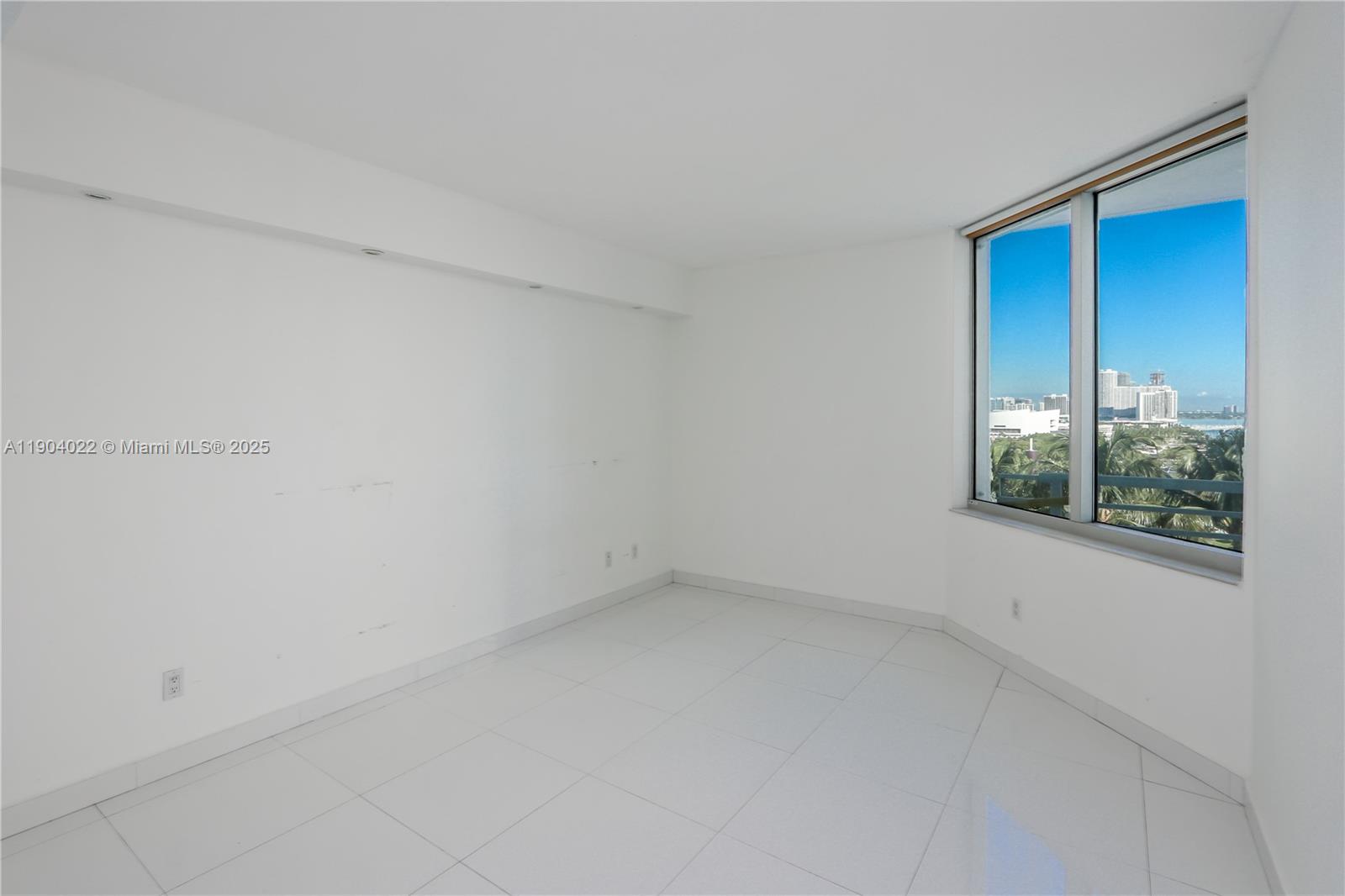 An empty room with white tile floors, white walls, and a window overlooking a city — 325 S Biscayne Blvd # 1722, Miami FL 33131, MIAMI, FL