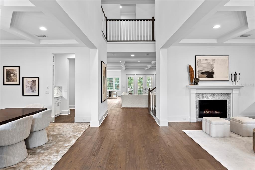 A bright, open-concept living area features hardwood floors, a fireplace, and a coffered ceiling — 5015 W LONGFELLOW AVENUE, TAMPA, FL