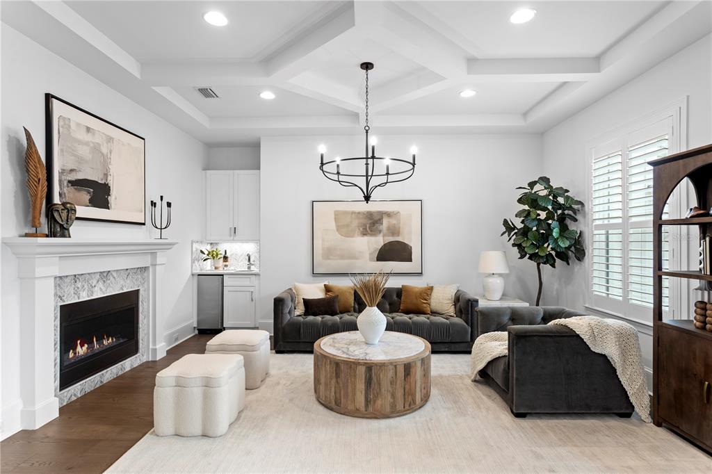 A living room features a fireplace, a wet bar, a chandelier, and a coffered ceiling — 5015 W LONGFELLOW AVENUE, TAMPA, FL