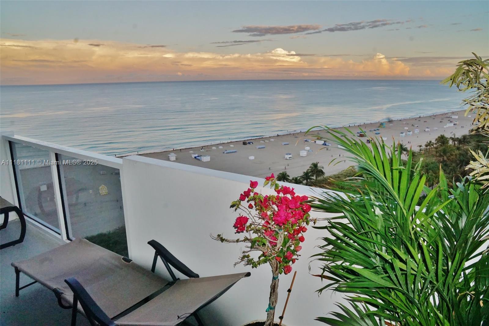 A balcony features a lounge chair, potted plants, and a view of the ocean beach — 100 Lincoln Rd # 1642, Miami Beach FL 33139, MIAMI BEACH, FL
