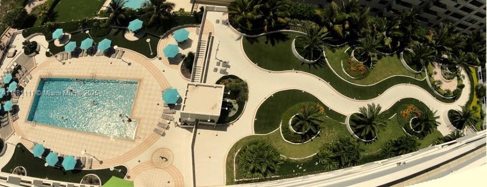 An aerial view shows a swimming pool surrounded by lounge chairs, umbrellas, and landscaped garden paths — 100 Lincoln Rd # 1642, Miami Beach FL 33139, MIAMI BEACH, FL