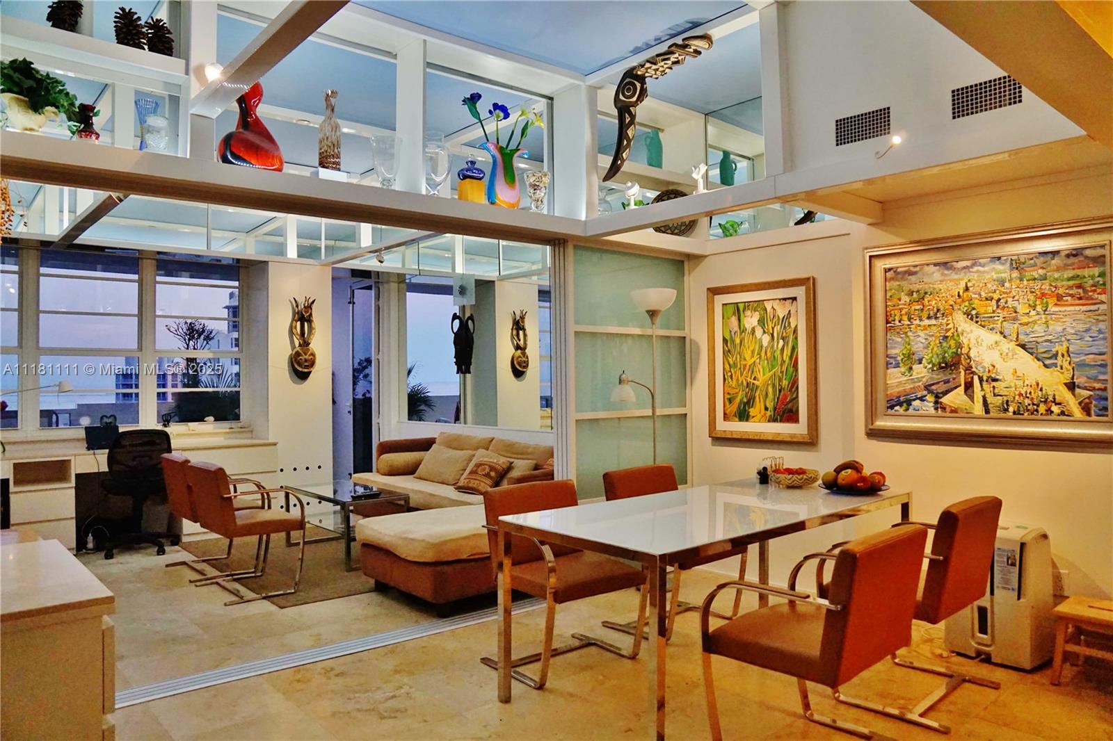 A dining area and living room feature modern furniture, tiled floors, and high display shelves — 100 Lincoln Rd # 1642, Miami Beach FL 33139, MIAMI BEACH, FL