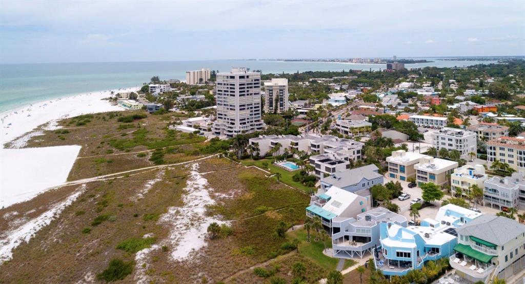 An aerial view of a coastal beach town with high-rise buildings and residential homes — 749 SIESTA DRIVE, SARASOTA, FL