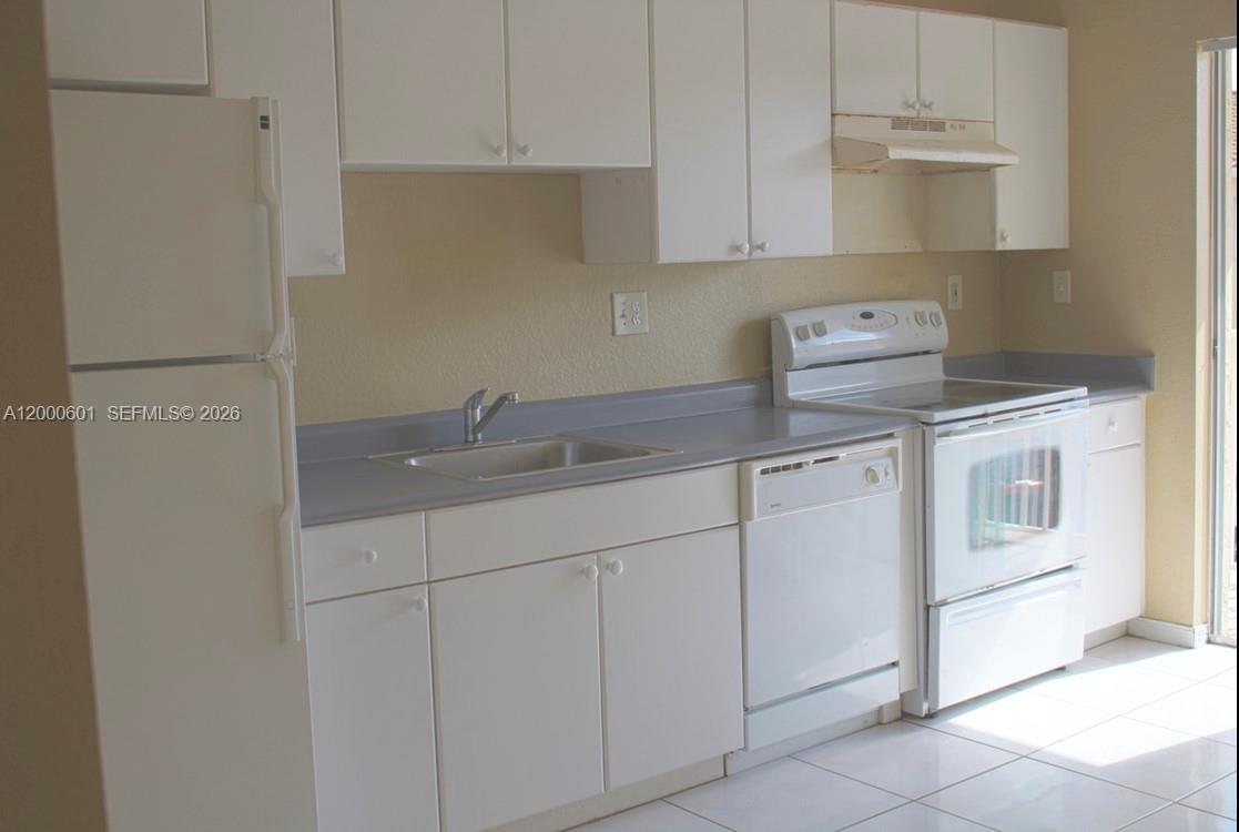 A kitchen features white cabinets, white appliances, and a gray countertop — 6962 NW 179th St # 6, Hialeah FL 33015, HIALEAH, FL