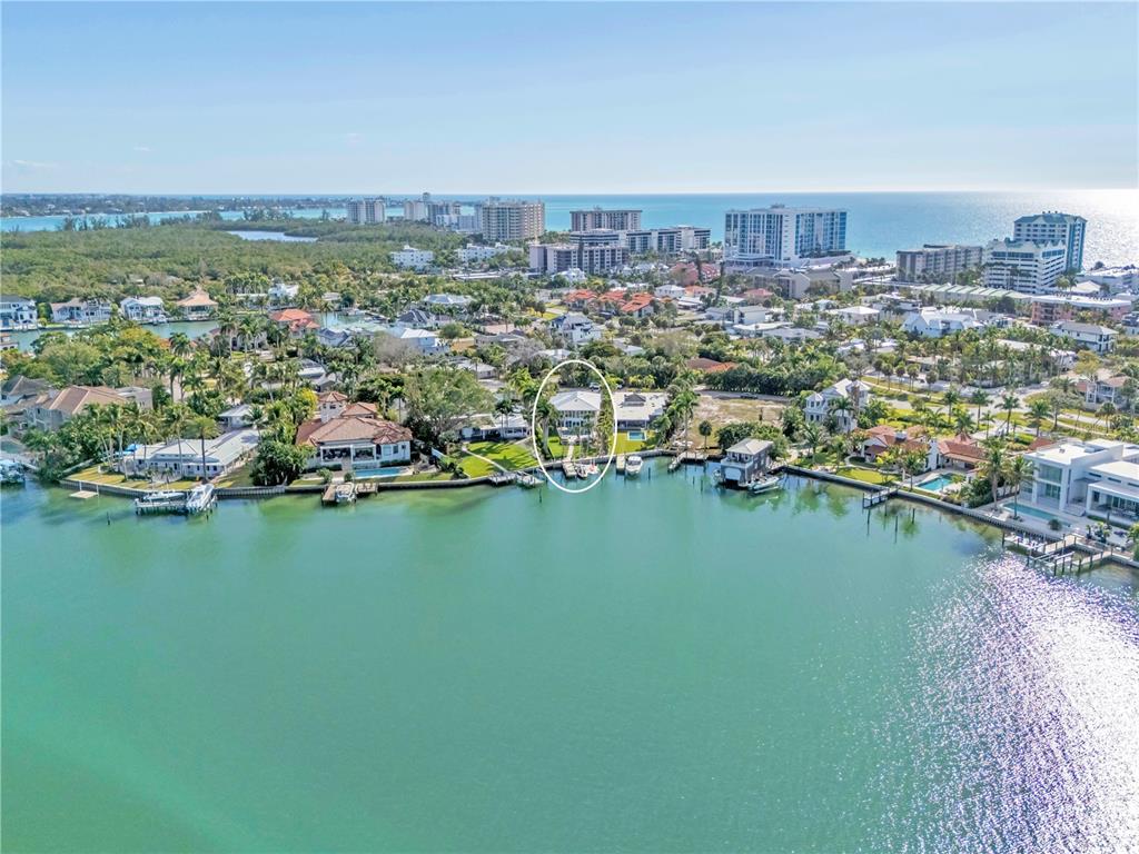 An aerial view shows a waterfront house with a boat dock on a canal — 701 TYLER DRIVE, SARASOTA, FL