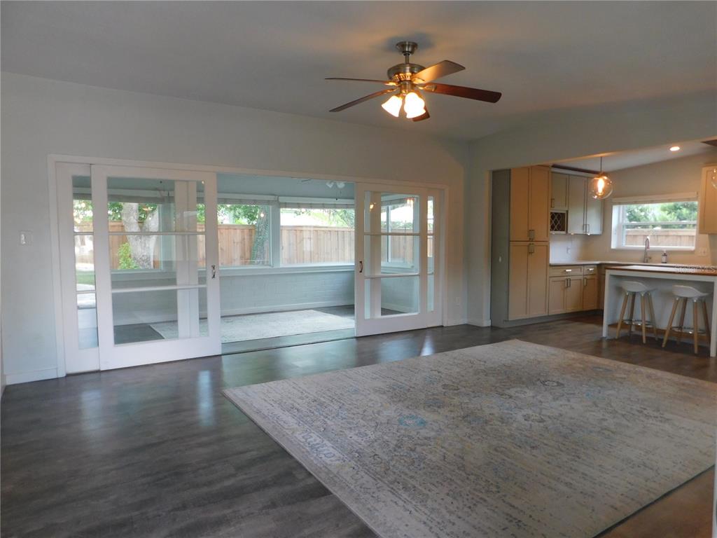 A living room with dark wood floors, a large area rug, and sliding glass doors — 2252 HOWARD DRIVE, WINTER PARK, FL