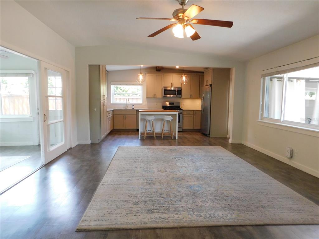 An open-concept kitchen with light cabinets and a central island overlooks a living area — 2252 HOWARD DRIVE, WINTER PARK, FL