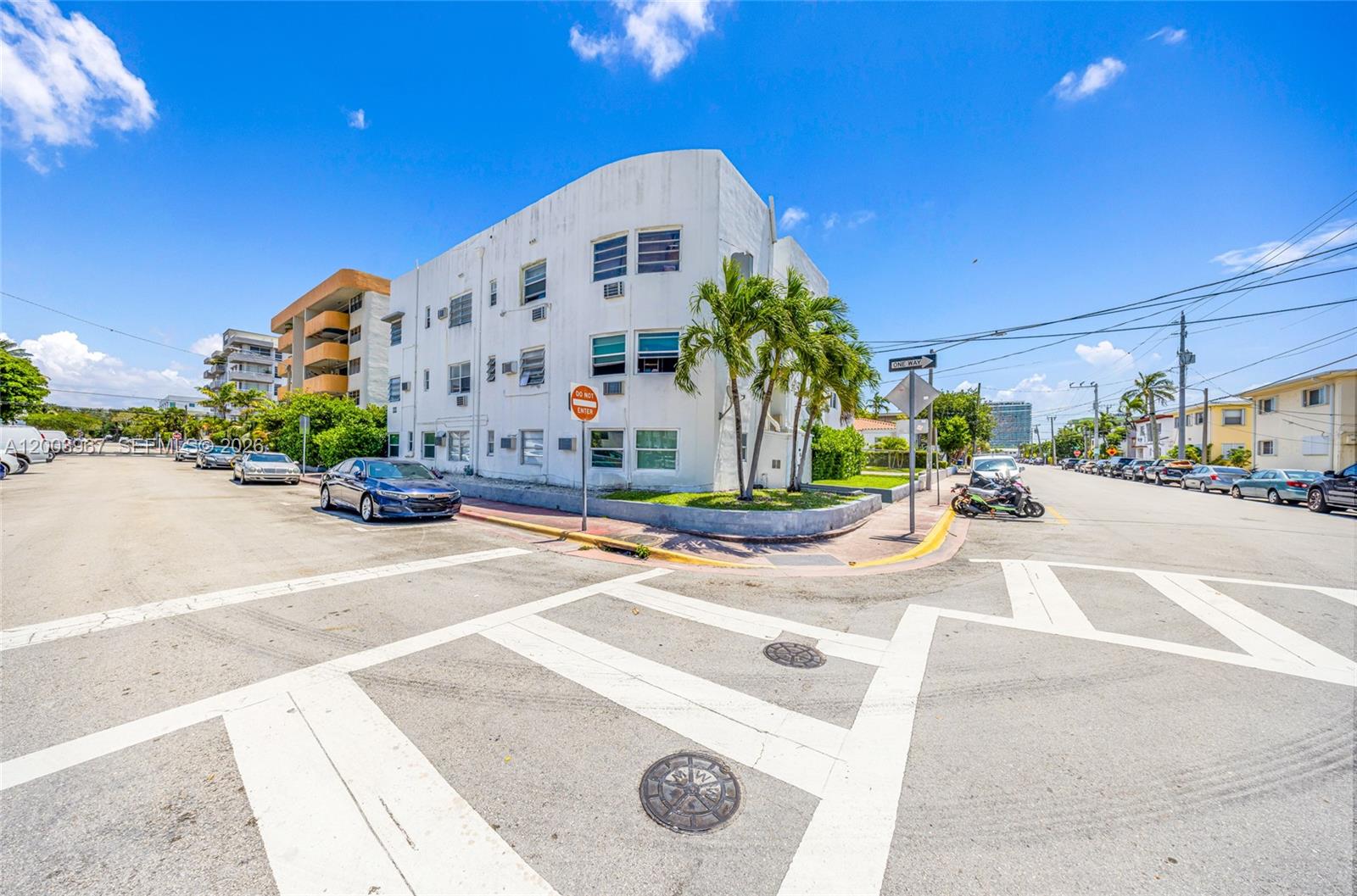A white multi-story apartment building stands on a street corner under a blue sky — 420 78th St, Miami Beach FL 33141, MIAMI BEACH, FL
