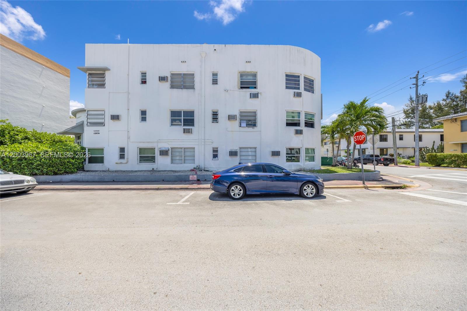 A blue sedan is parked in front of a three-story white apartment building — 420 78th St, Miami Beach FL 33141, MIAMI BEACH, FL