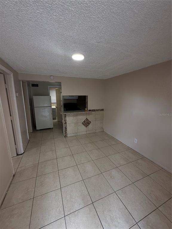 A tiled dining area features a pass-through window to the kitchen and a white refrigerator — 4570 TRANSPORT ROAD, BARTOW, FL