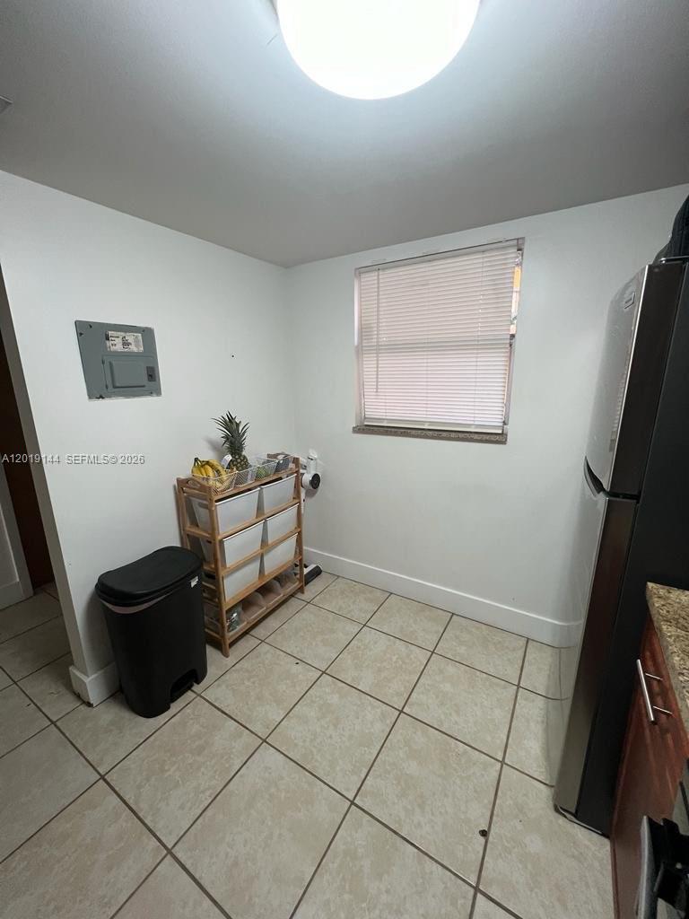 A kitchen corner features tile flooring, a window with blinds, and a storage rack — 18051 NW 68th Ave # K103, Hialeah FL 33015, HIALEAH, FL