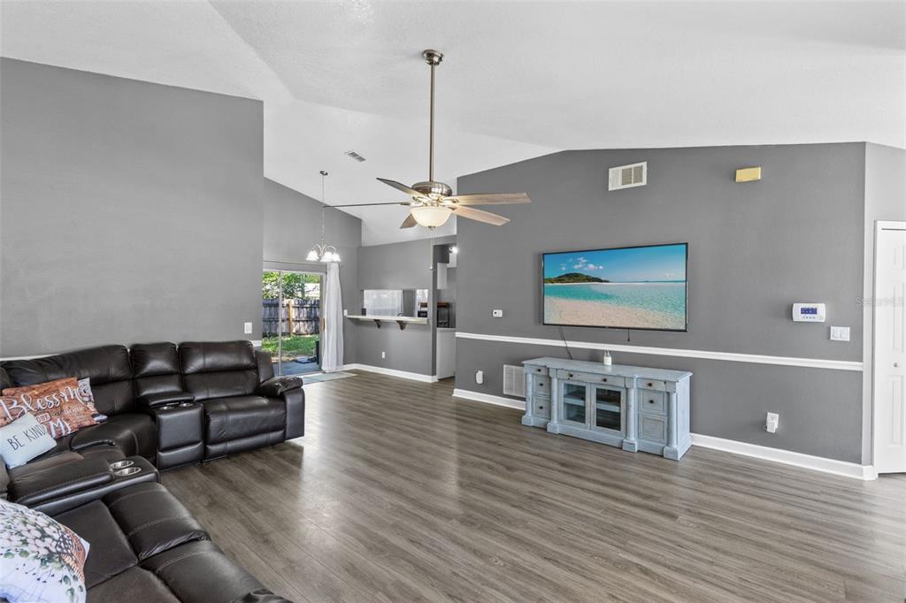 A bedroom features gray walls, dark carpet, a ceiling fan, and an open closet — 601 ARLINGTON COURT, EUSTIS, FL