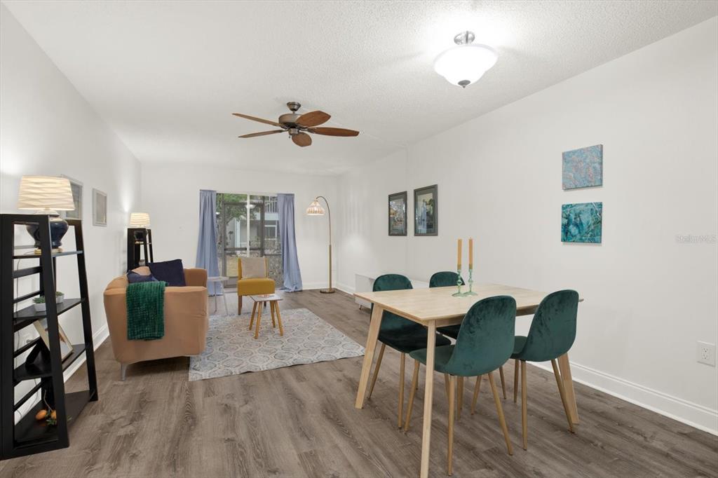 A living and dining area with wood-look flooring, a ceiling fan, and sliding glass doors — 235 S MCMULLEN BOOTH ROAD UNIT 45, CLEARWATER, FL