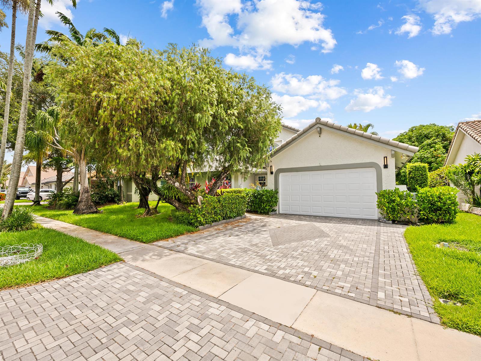 A single-story house with a white garage door and a paved driveway — 1750 W Oak Knoll Circle, Davie FL 33324, DAVIE, FL