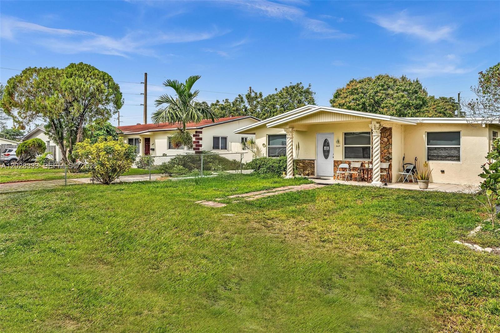 A single-story house with a yellow exterior, a covered porch, and a grassy front yard — 2631 NE 214th St # 00, Miami FL 33180, MIAMI, FL