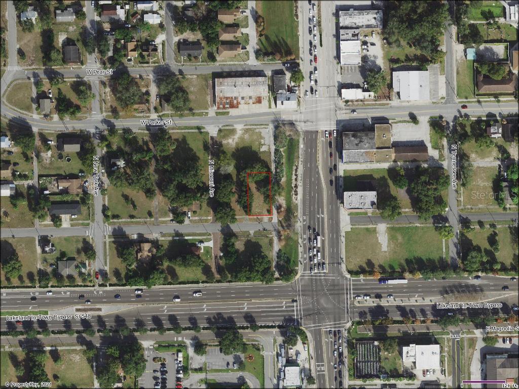 This is an aerial map showing a vacant lot outlined in red near a highway intersection — 115 W MYRTLE STREET, LAKELAND, FL
