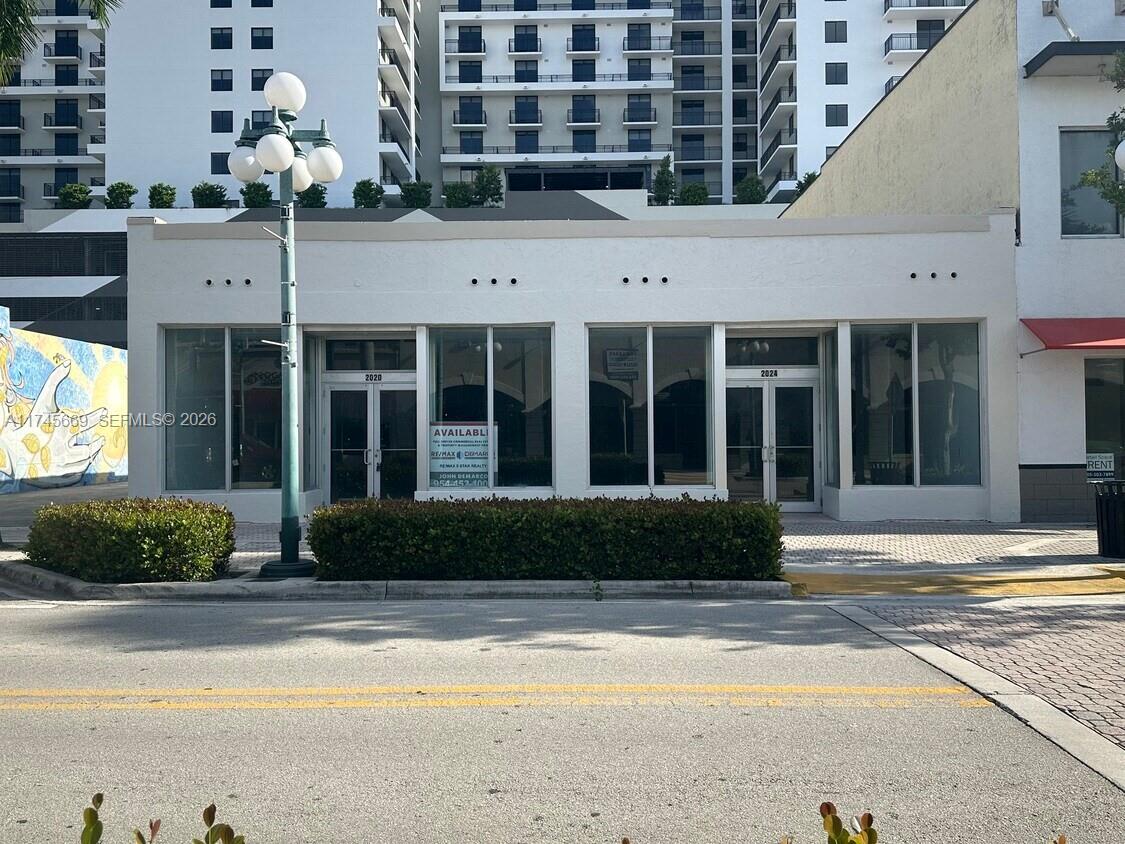 A single-story commercial building with two glass storefront entrances and a street-side hedge — 2020 Harrison St, Hollywood FL 33020, HOLLYWOOD, FL