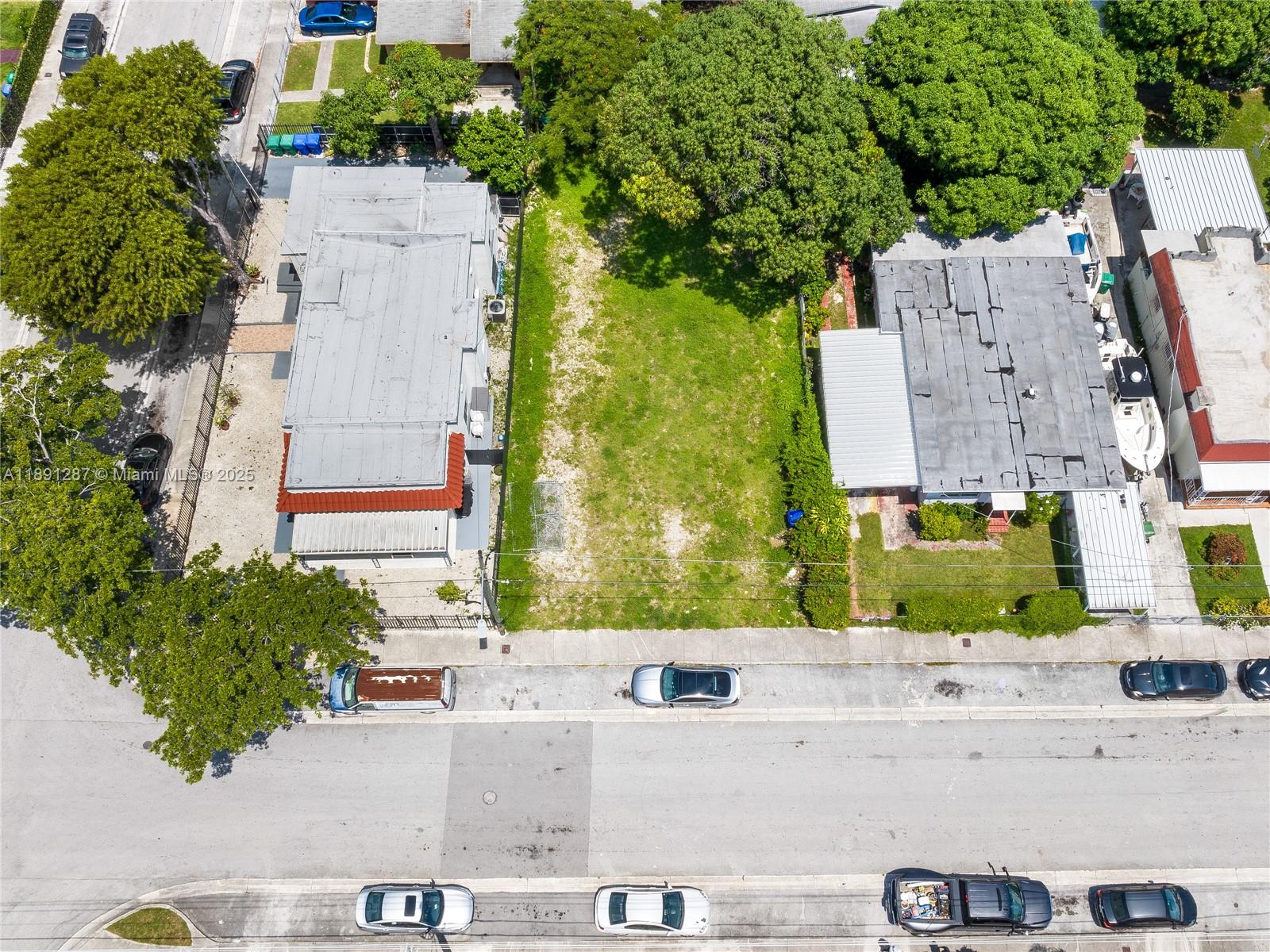 An aerial view shows a vacant rectangular lot situated between two residential houses — 1881 NW 4th St, Miami FL 33125, MIAMI, FL