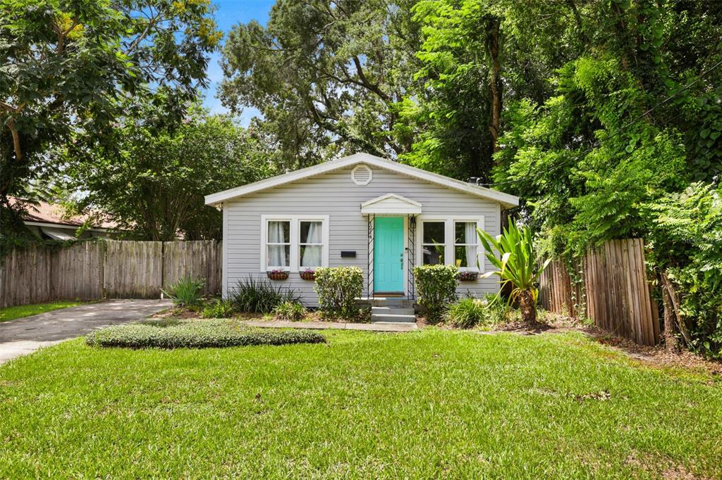 A single-story gray house with a bright teal front door and a grassy front yard — 1214 E HARDING STREET, ORLANDO, FL