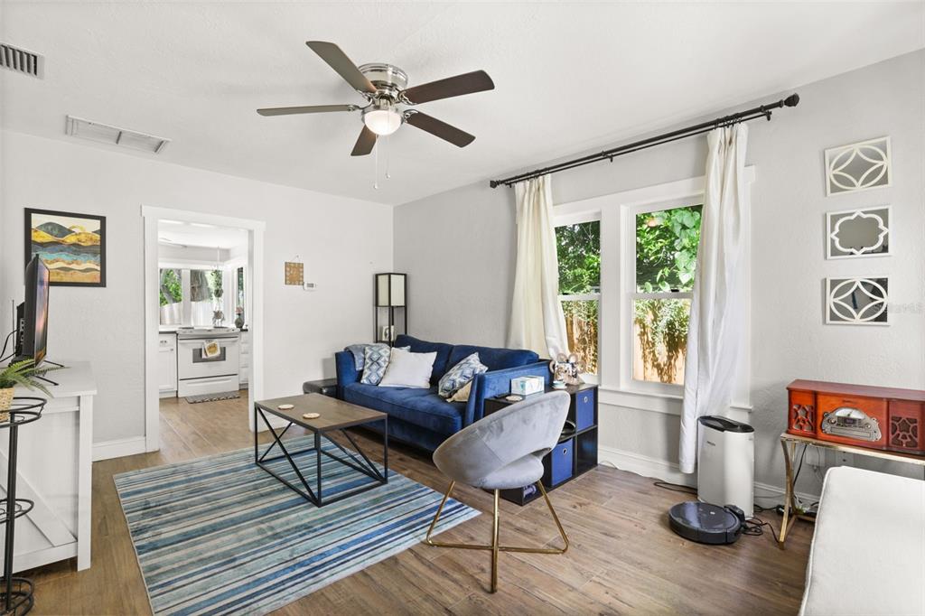 A living room features a blue sofa, a striped rug, and a ceiling fan — 1214 E HARDING STREET, ORLANDO, FL