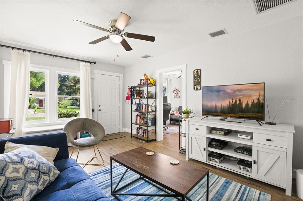 A living room features a blue sofa, a wooden coffee table, and a white media console — 1214 E HARDING STREET, ORLANDO, FL