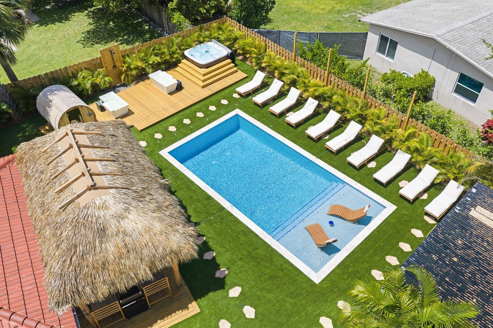 An aerial view of a backyard featuring a swimming pool, hot tub, and lounge chairs — 275 NE 16th Street, Delray Beach FL 33444, DELRAY BEACH, FL