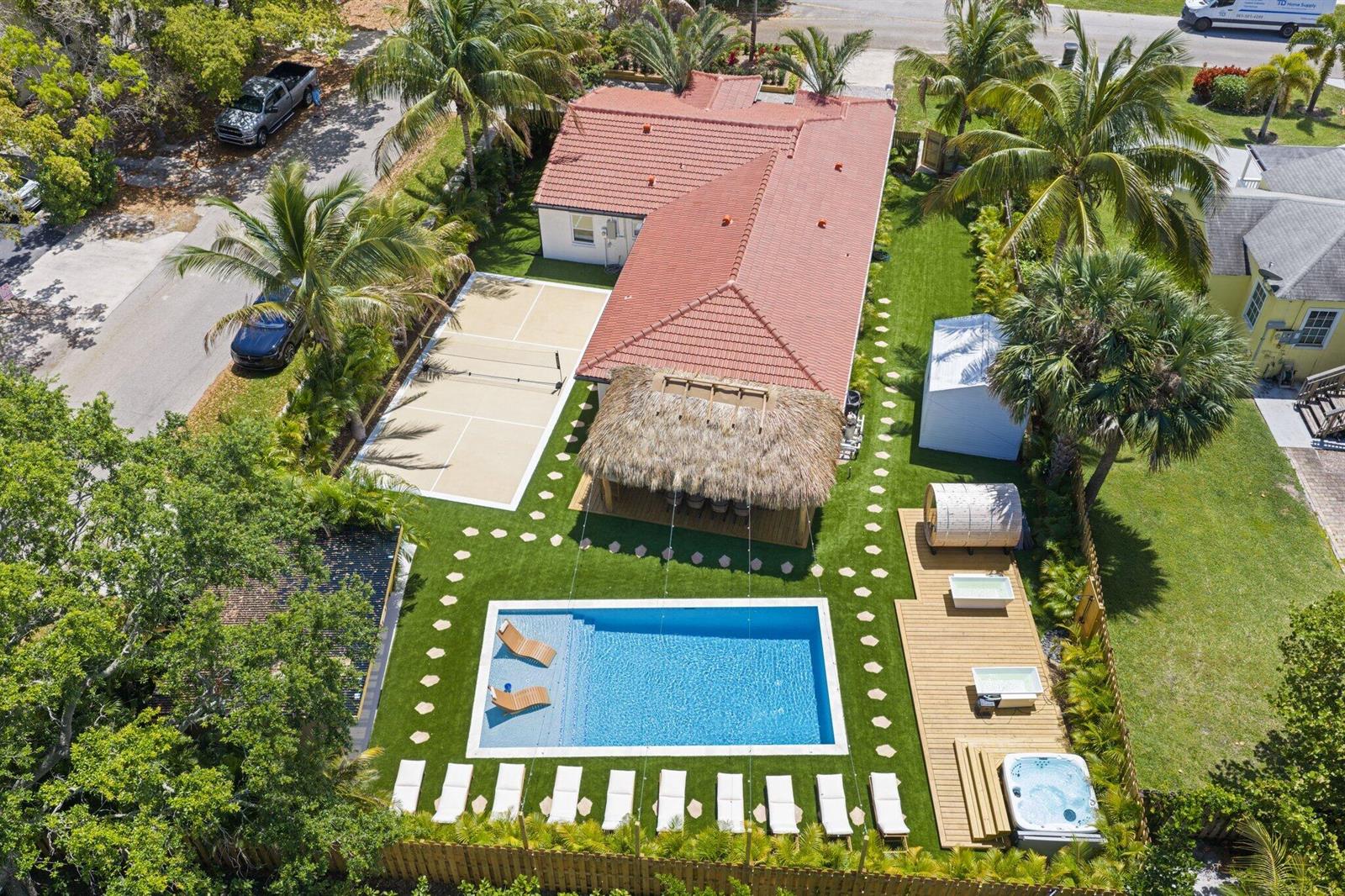 An aerial view of a backyard featuring a swimming pool, pickleball court, and tiki hut — 275 NE 16th Street, Delray Beach FL 33444, DELRAY BEACH, FL