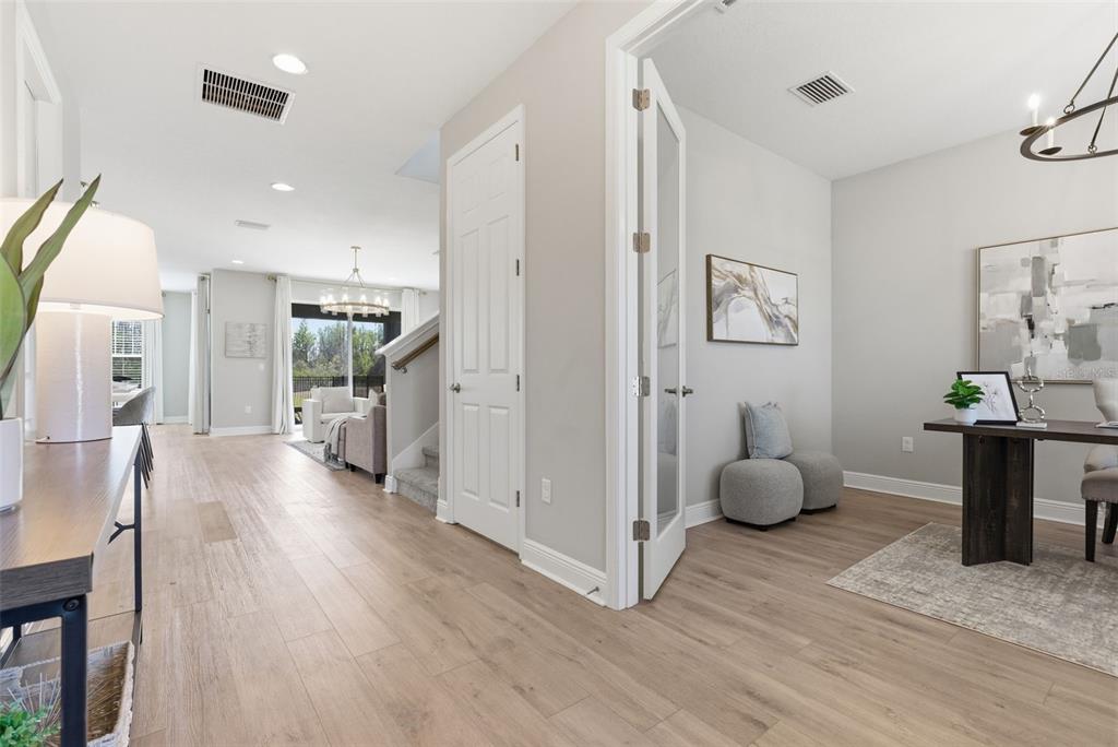 A hallway leads to a living area, with a home office visible through French doors — 17674 EVERLONG DRIVE, LAND O LAKES, FL