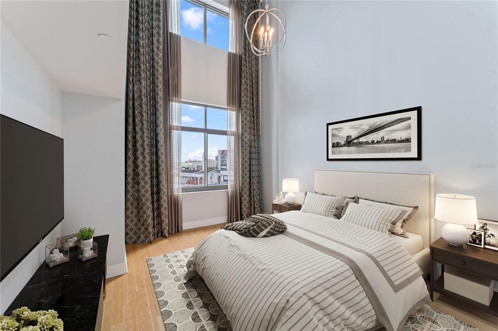 A bedroom with high ceilings, tall windows, a striped bed, and a black television console — 1108 N FRANKLIN STREET UNIT 707, TAMPA, FL