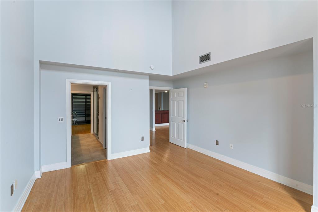 An empty room with light blue walls, high ceilings, and light-colored wood flooring — 1108 N FRANKLIN STREET UNIT 707, TAMPA, FL
