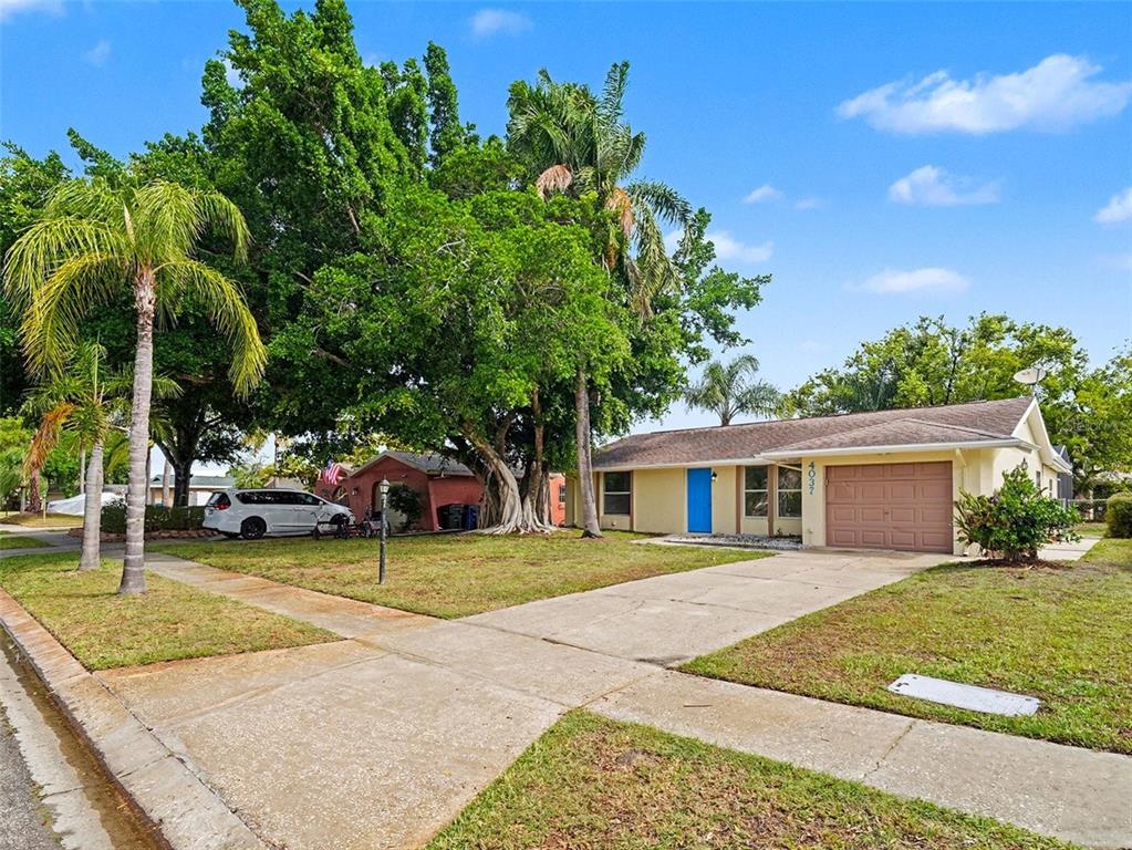 A single-story house with a tan exterior, a brown garage door, and a blue front door — 4037 MAVERICK AVENUE, SARASOTA, FL