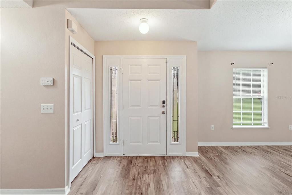 A two-story beige house with a white front door and a single-car garage — 10078 N CARVER WAY, CITRUS SPRINGS, FL