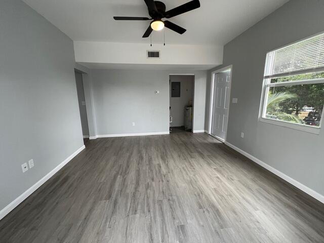 An empty room with gray walls, wood-look flooring, a ceiling fan, and a window — 520 N E Street, FL 33460, FL