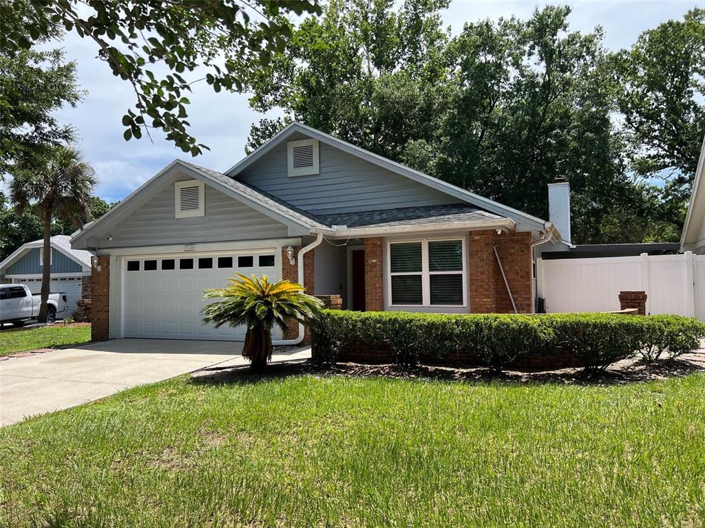 A single-story house with a brick and gray siding exterior, a garage, and a lawn — 3159 BERRIDGE LANE, ORLANDO, FL
