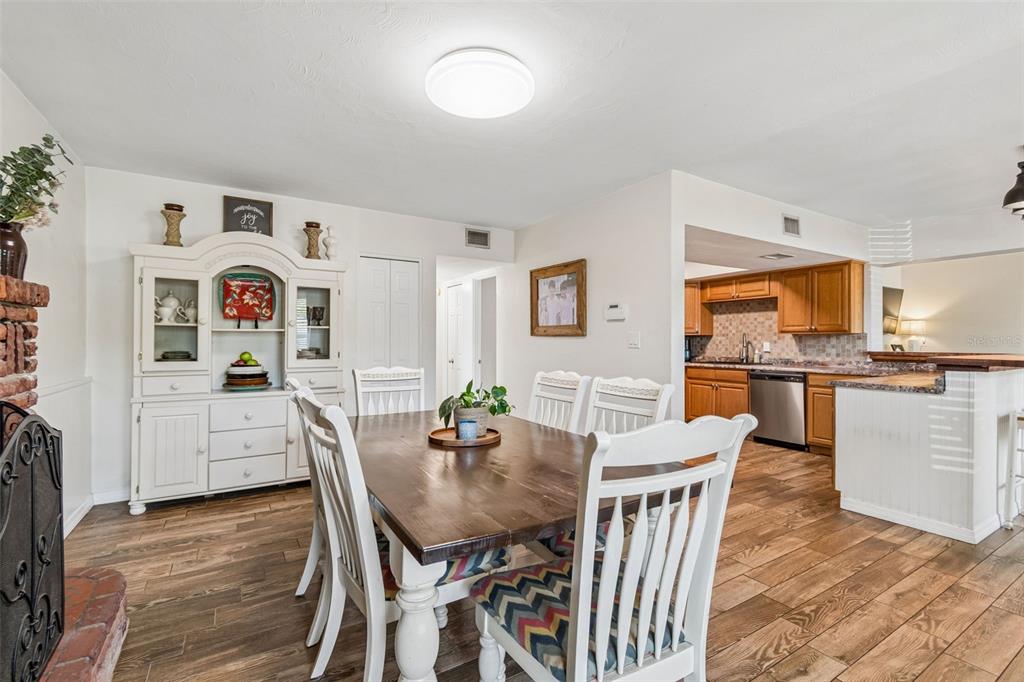 A kitchen with wood cabinets and a breakfast bar opens into a living room area — 10748 VILLAGE GREEN AVE, SEMINOLE, FL