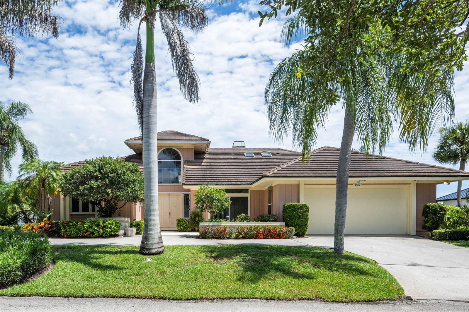 A single-story house with a brown tile roof, palm trees, and a two-car garage — 3500 Marsha Lane, Vero Beach FL 32967, VERO BEACH, FL