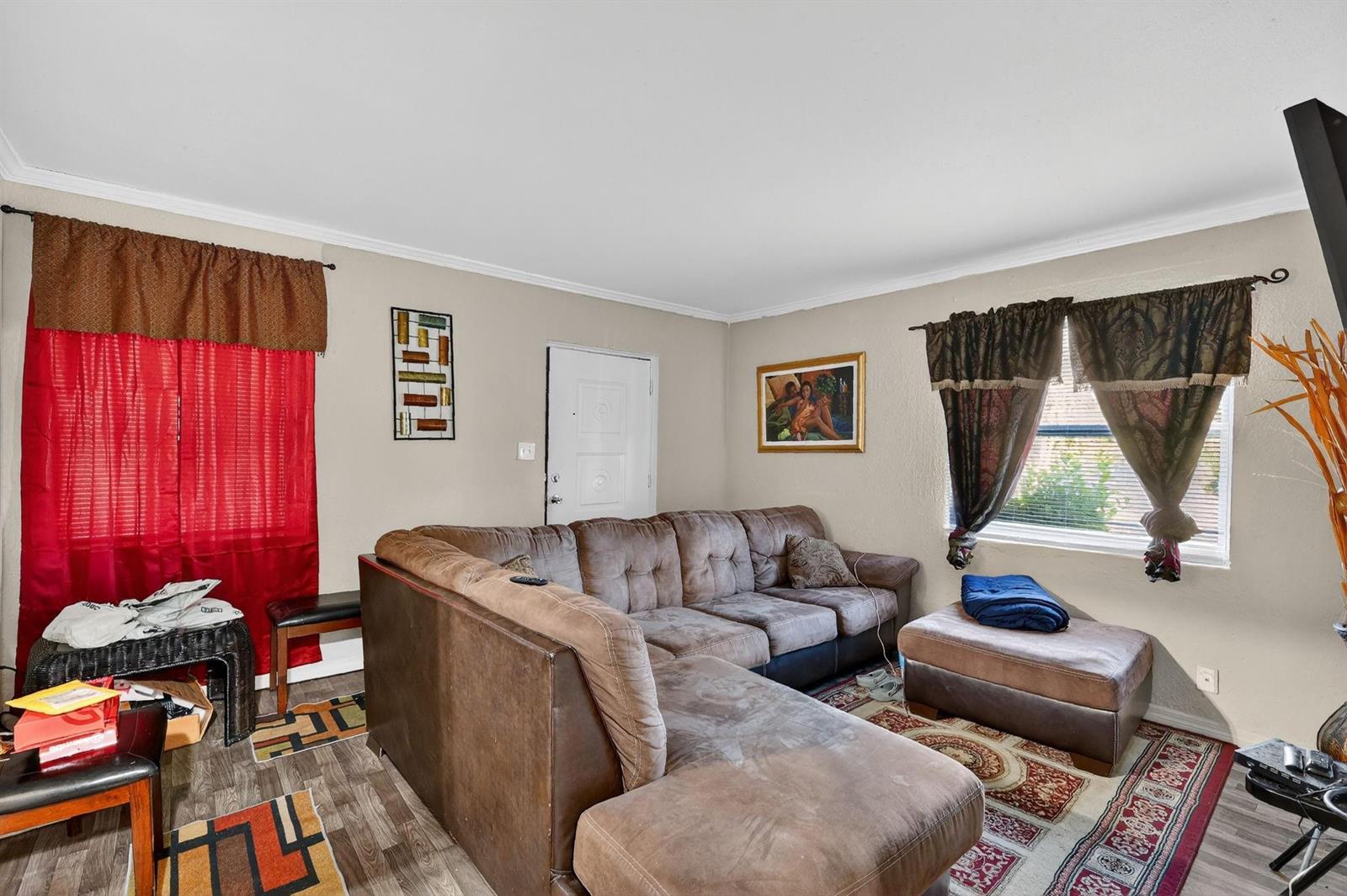 A living room features a large brown sectional sofa, a patterned rug, and red curtains — 1030 NW 13 Avenue, FL 34475, FL
