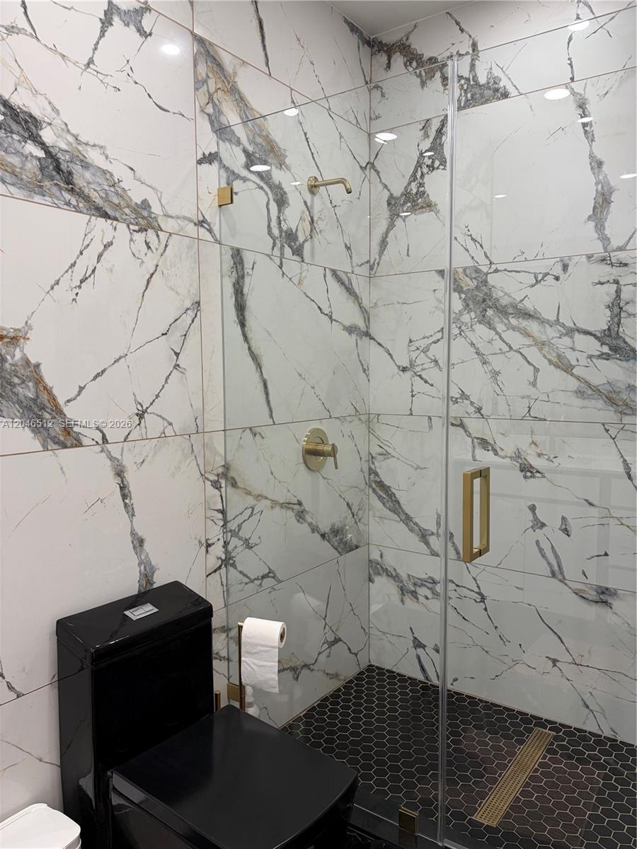 A bathroom features white marble-patterned wall tiles, a black toilet, and a glass-enclosed shower — 3409 W 92nd Pl # 3409, Hialeah FL 33018, HIALEAH, FL