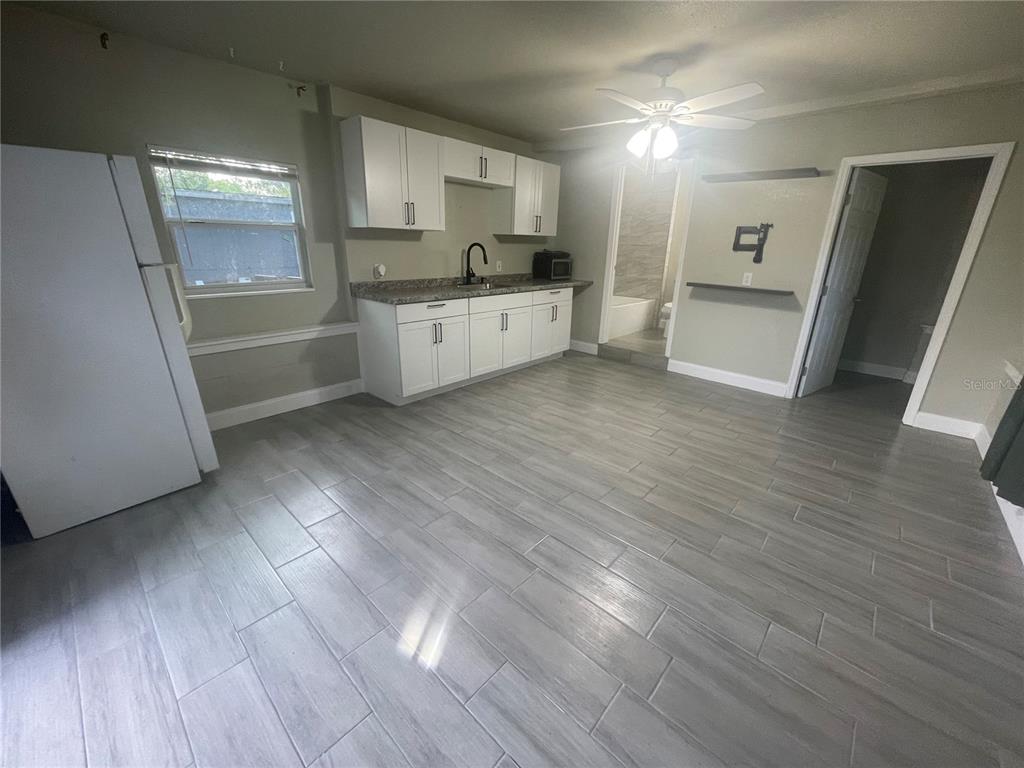 A kitchen with white cabinets, gray countertops, and light gray wood-look tile flooring — 3419 19TH STREET E UNIT Back ADU, BRADENTON, FL