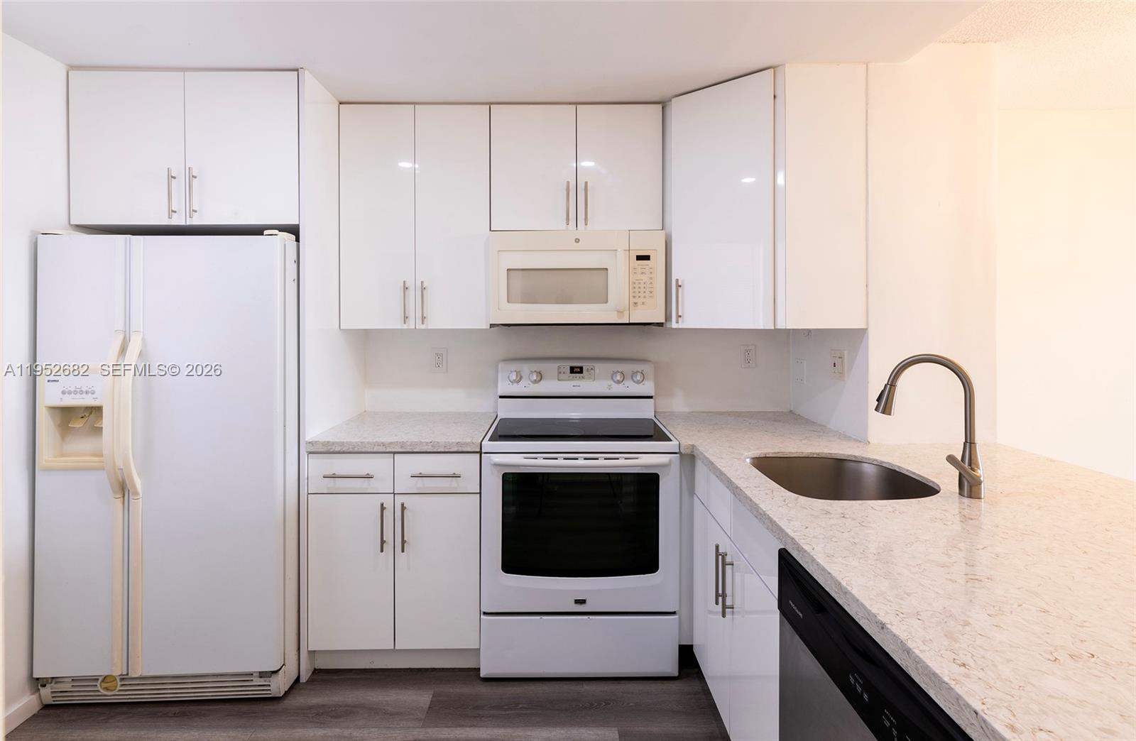 A kitchen features white cabinets, a white stove, a refrigerator, and a stainless steel sink — 19701 SW 114th Ave # 364, Miami FL 33157, MIAMI, FL