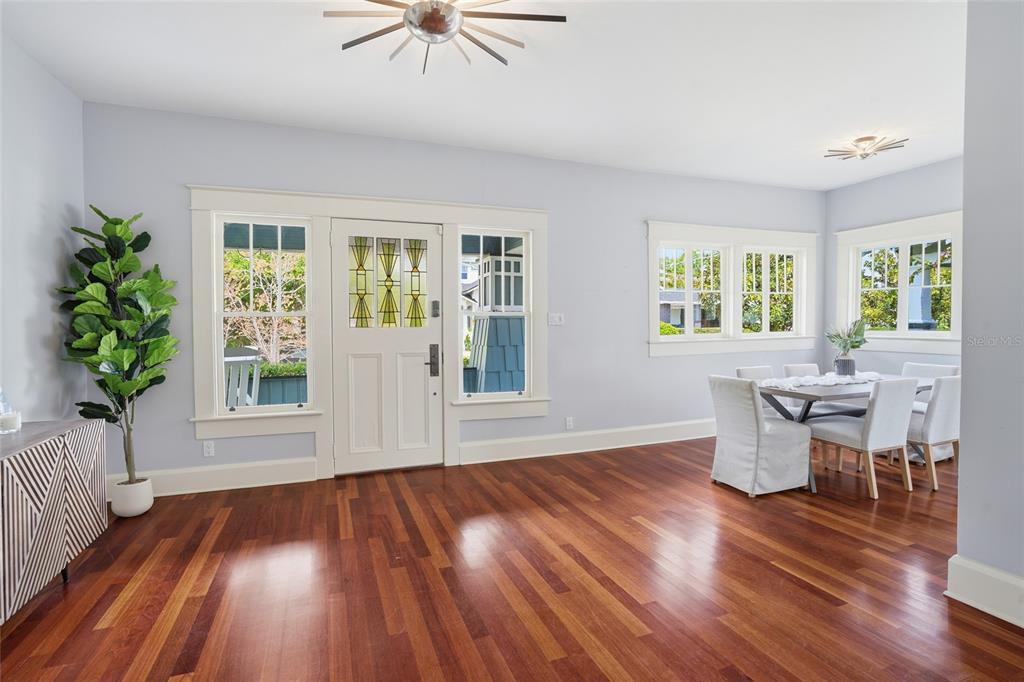 A dining area with hardwood floors, a front door, and a dining table with chairs — 2116 W WATROUS AVENUE, TAMPA, FL
