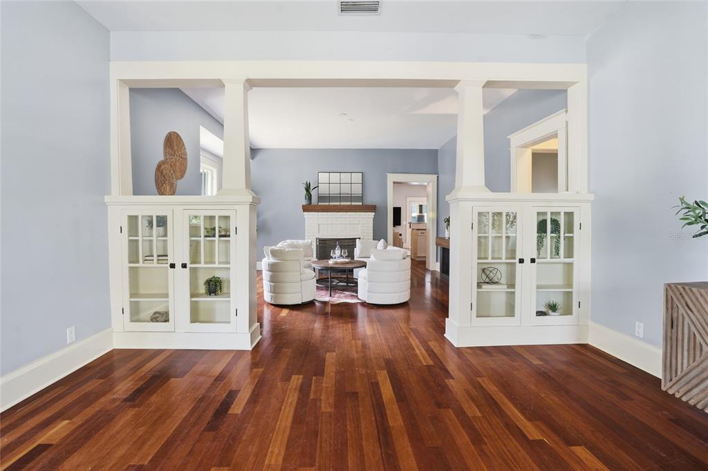A living room with hardwood floors, a white fireplace, and built-in glass-front cabinets — 2116 W WATROUS AVENUE, TAMPA, FL