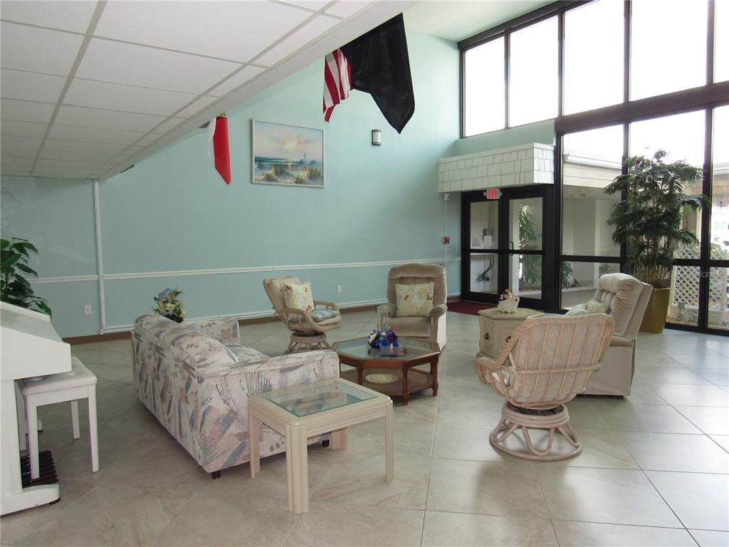 A lobby with tile floors, a seating area, and large windows overlooking an outdoor area — 21260 BRINSON AVENUE UNIT 212, PORT CHARLOTTE, FL