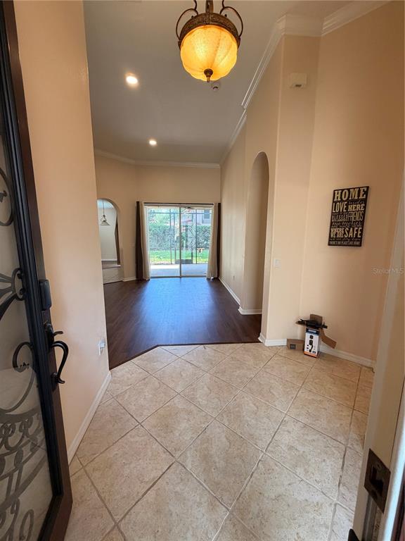 An entryway with tile flooring leads into a living area with dark wood-look floors — 11316 RAPALLO LANE, WINDERMERE, FL
