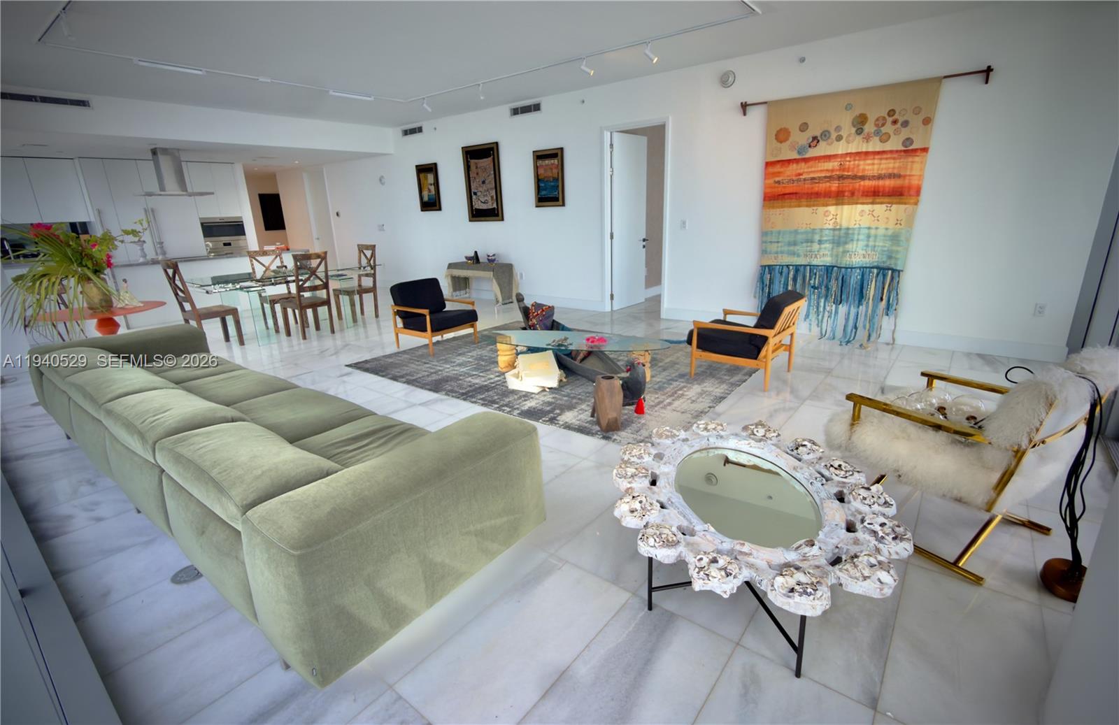 A spacious living room features a green sofa, glass coffee table, and white marble floors — 700 NE 26th Terrace # 4403, Miami FL 33137, MIAMI, FL