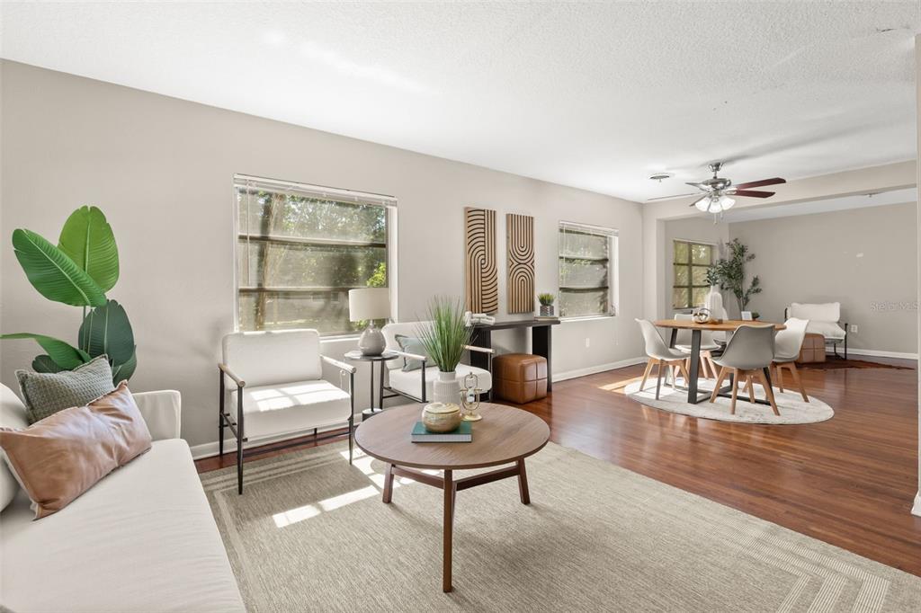 A living room with hardwood floors, a round coffee table, and an adjacent dining area — 820 RUGBY STREET, ORLANDO, FL